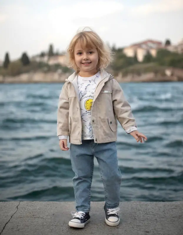 Günlük kıyafetler içinde gülümseyen çocuk.