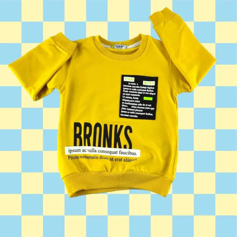 Sarı sweatshirt ve siyah pantolon giyen yürümeye başlayan çocuk.