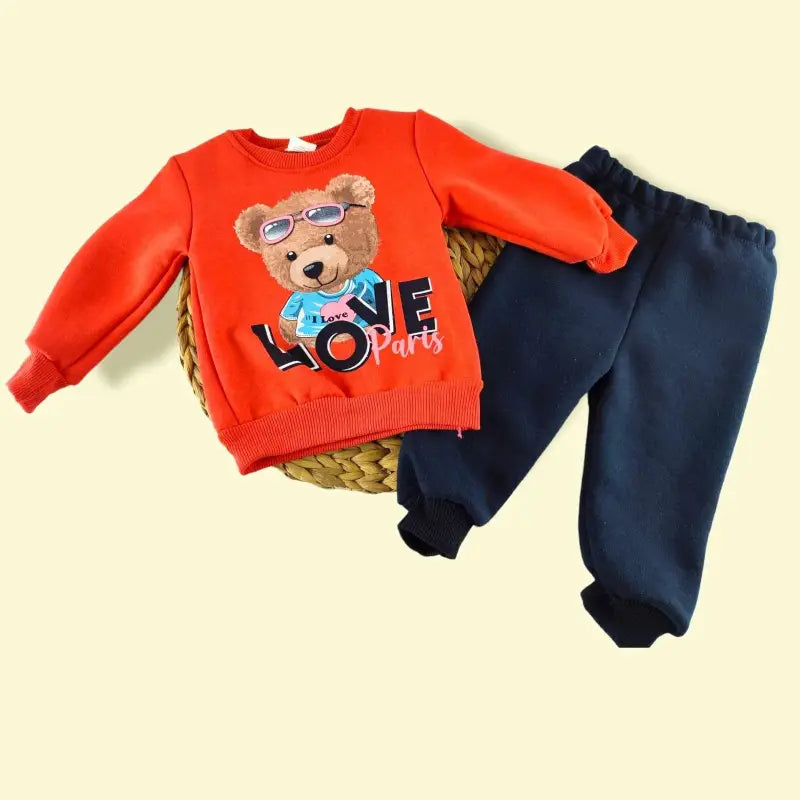 Çocuk turuncu sweatshirt ve koyu mavi eşofman altı takımı.