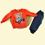 Çocuk turuncu sweatshirt ve mavi pantolon takımı.