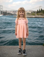 Pembe elbiseli gülümseyen kız.